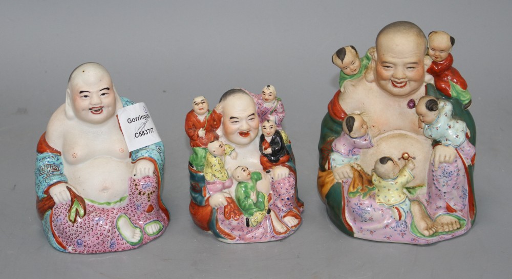Three Chinese famille rose groups of Budai, mid 20th century, two modelled with children and with impressed makers marks, 10cm - 15cm